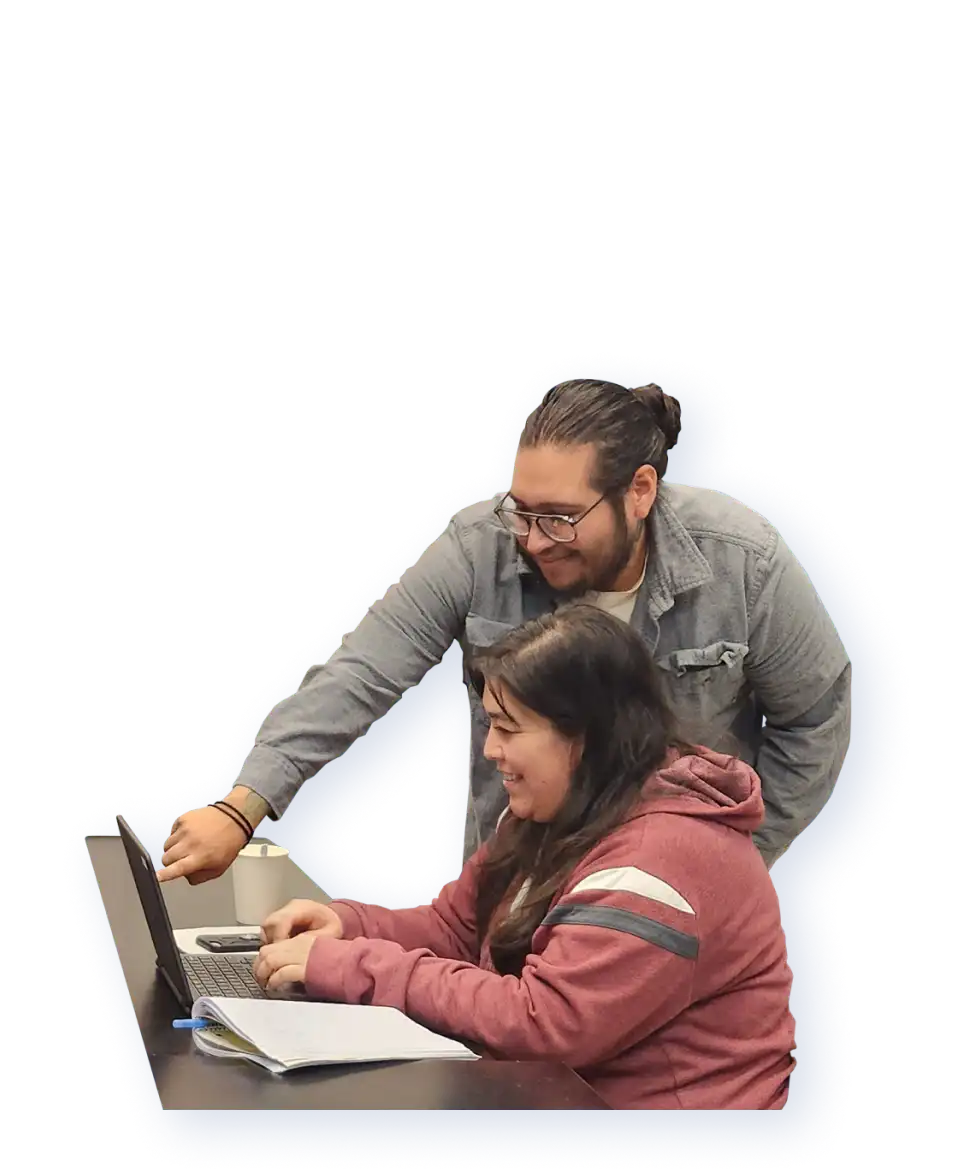 A Digital Skills for Life instructor provides encouragement to a participant while pointing to an area on their laptop.